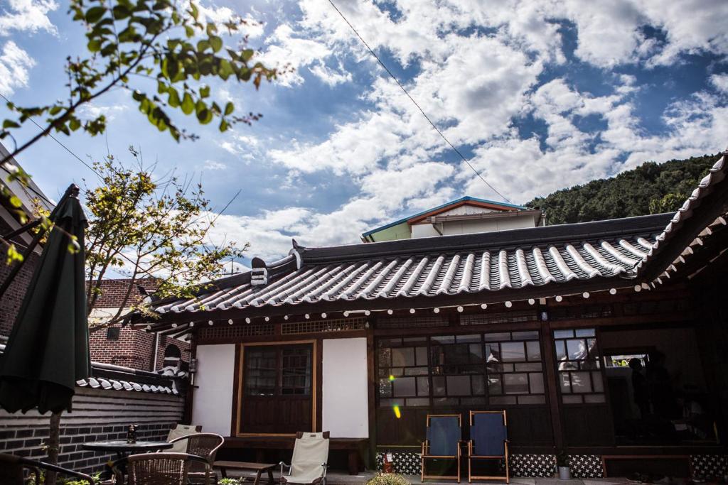 a house with a roof with chairs in front of it at Bonghwangjae Hanok Guesthouse in Gongju
