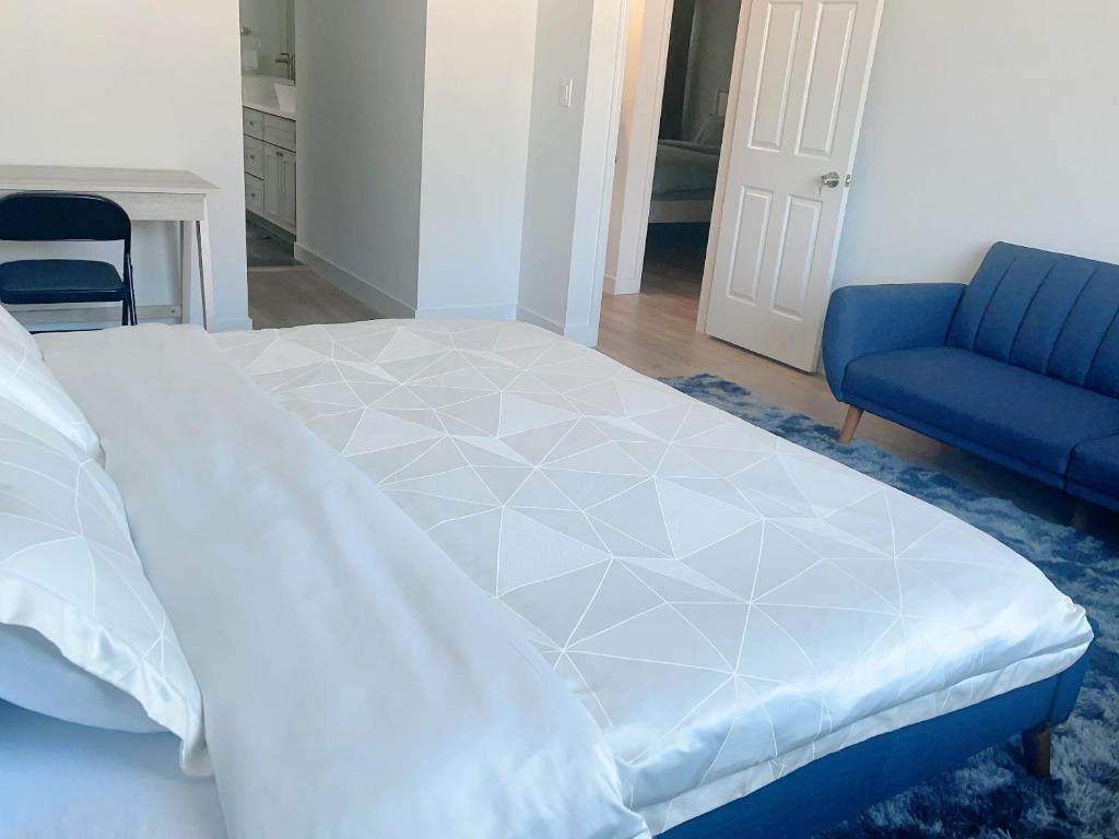 uma cama grande num quarto com uma cadeira azul em 靠近舊金山國際機場的民宿 em Daly City