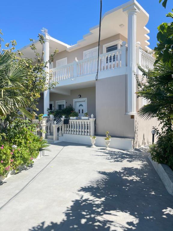 a large white house with a driveway at Guest House Narta in Vlorë