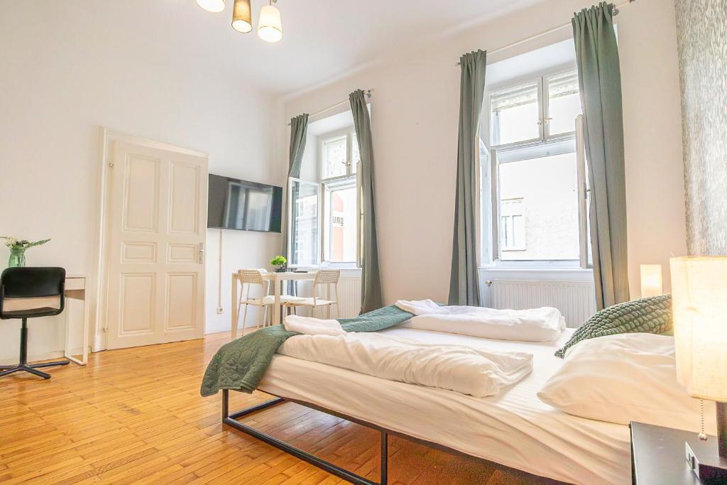 1 dormitorio con 1 cama grande y 2 ventanas en Friendly 2BR Apt- Near Rennweg & Belvedere Palace en Viena