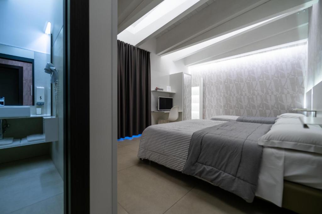 - une chambre avec un grand lit et une télévision dans l'établissement La Dimora Del Re, à Bitritto