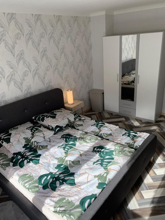 a bedroom with a bed with a floral comforter at Haus Nummer Vier in Neunkirchen