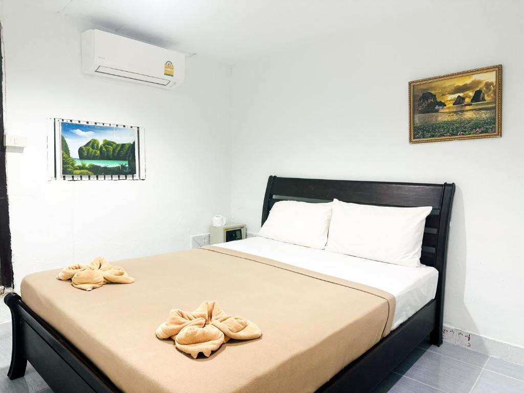 Un dormitorio con una cama con dos pares de zapatos. en Bang sit Guest House en Islas Phi Phi