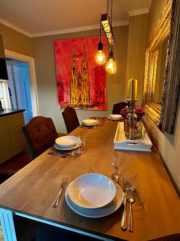 a dining room table with plates and glasses on it at Deluxe Altbaucharme in zentraler Lage in Kiel