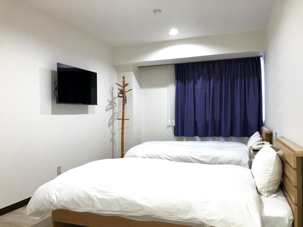 1 dormitorio con 2 camas y TV. en Anan Daiichi Hotel - Vacation STAY 13421v en Anan