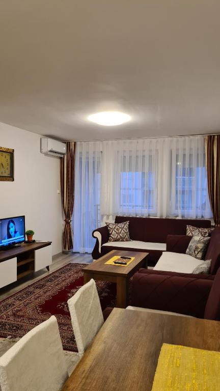 ein Wohnzimmer mit einem Sofa und einem Tisch in der Unterkunft Fush Kosov Apartment Center in Kosovo Polje