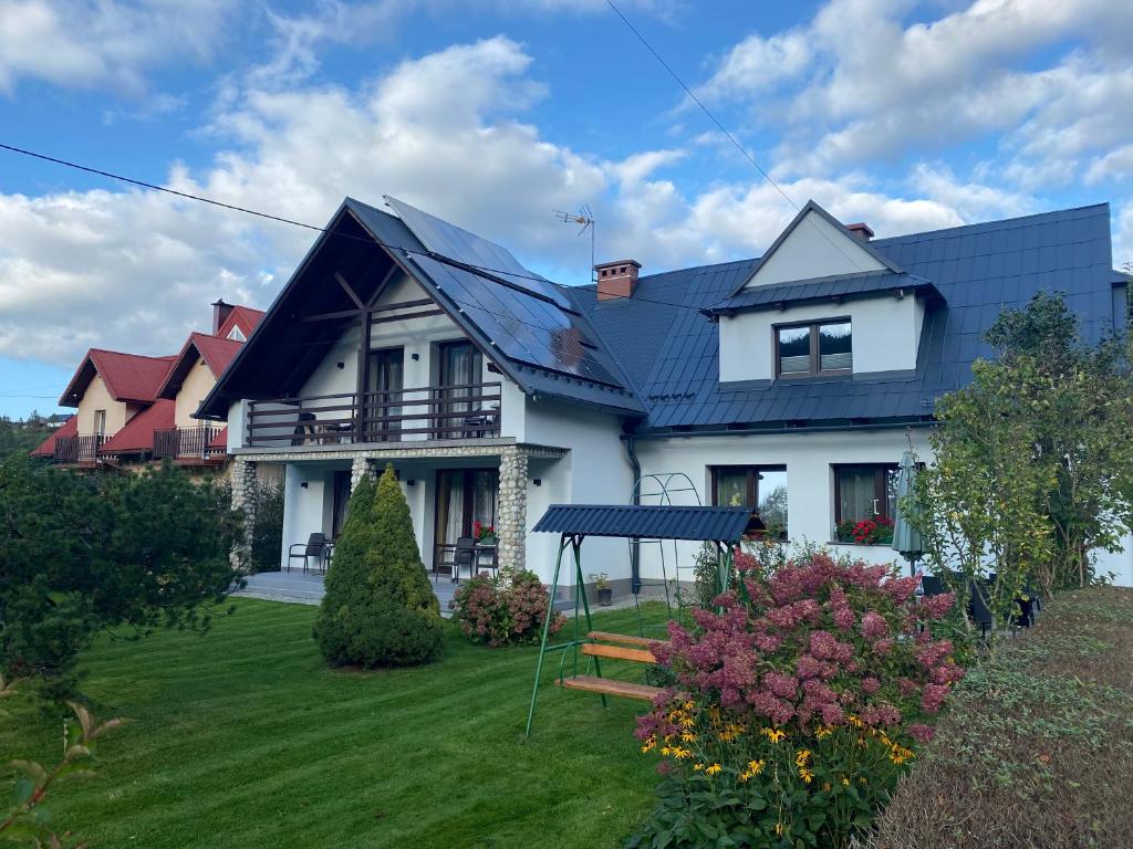een groot wit huis met een blauw dak bij Anna Pokoje Gościnne in Krościenko