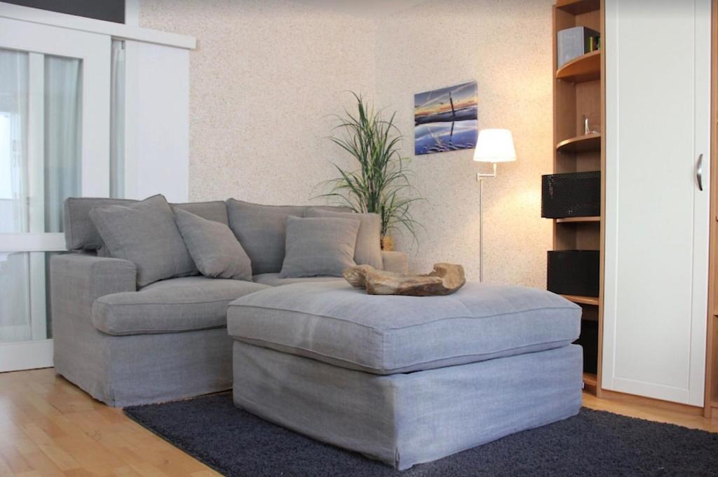 uma sala de estar com um sofá e um gato sentado num repousa-pés em Haus Sonnenhaken Wohnung 1 em Norderney