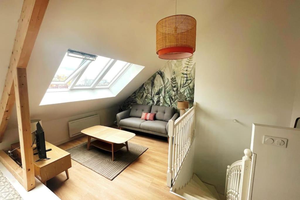 uma sala de estar com um sofá e uma janela em Le loft em Saint-Nazaire