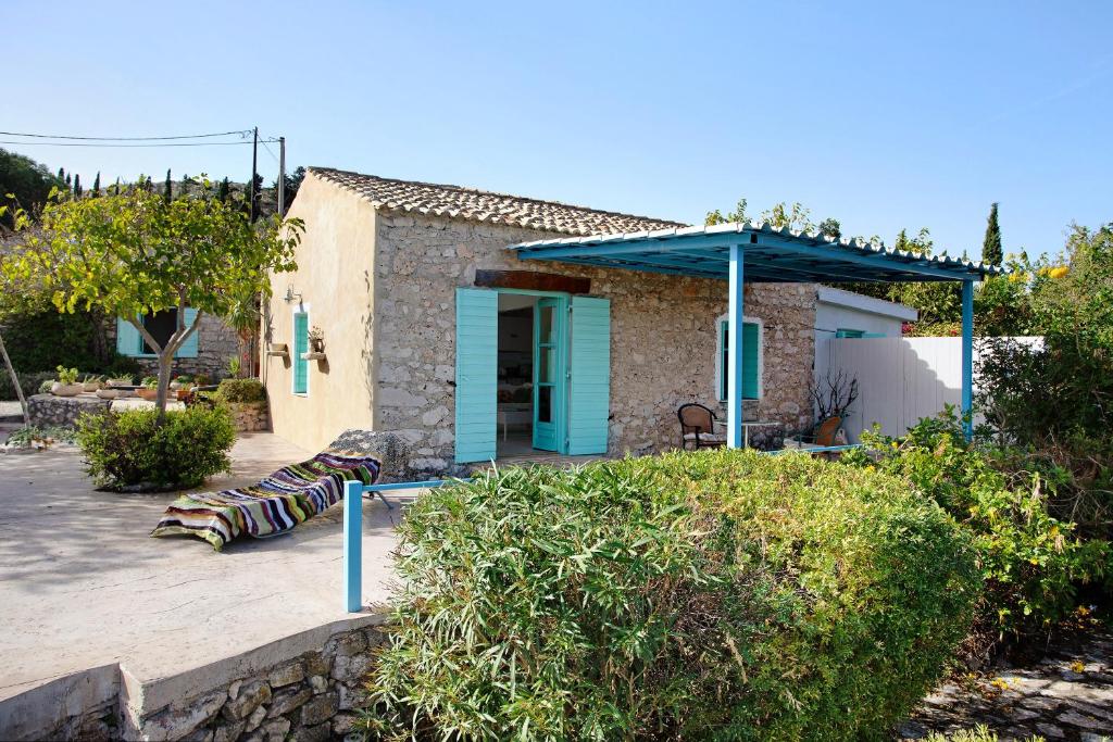 ein kleines Haus mit einer blauen Tür und einer Terrasse in der Unterkunft Sira Stonehouse l in Volímai