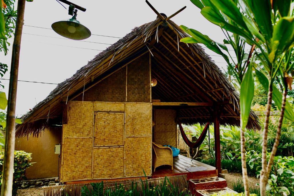 a small hut with a thatched roof at Rinjani Lighthouse in Senaru