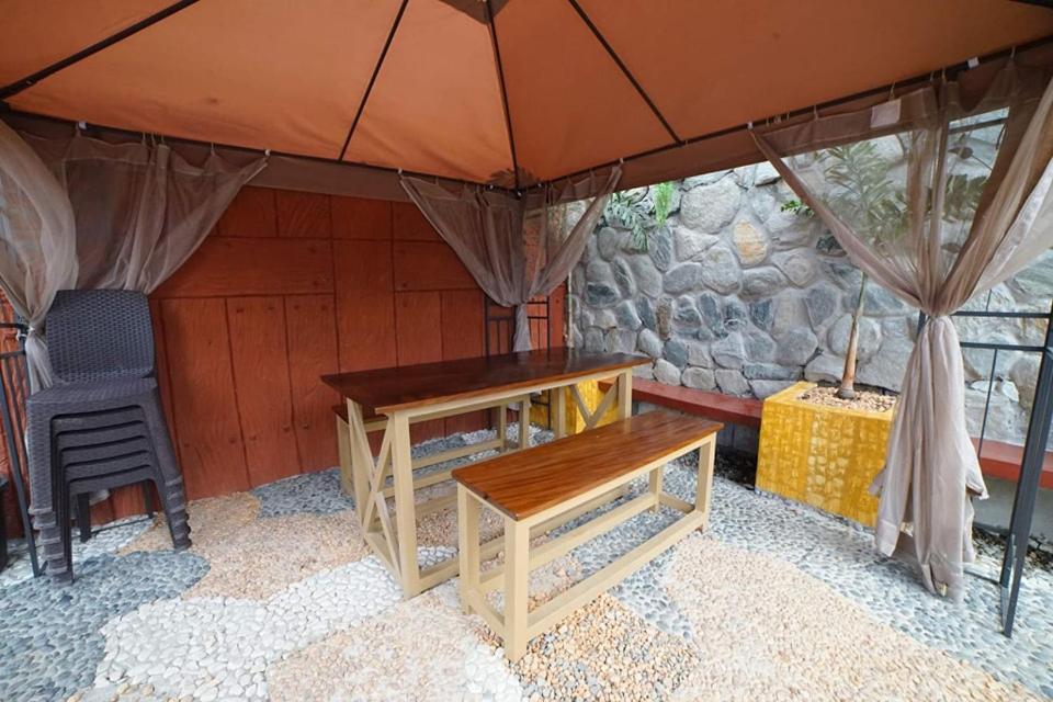 une tente avec une table en bois et une chaise dans l'établissement The Cabin by Grey - Vacation House and Events Place, à Kawit