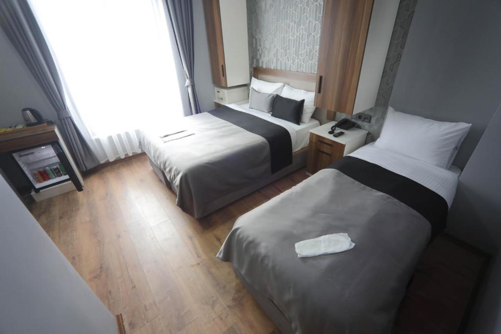 a hotel room with two beds and a window at Yuvam akmarmara hotel in Istanbul