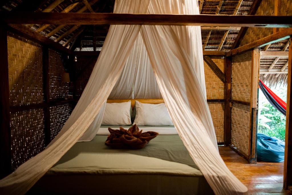 a bed in a room with a mosquito net at Rinjani Lighthouse in Senaru
