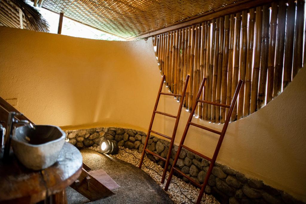 a room with a ladder next to a wall at Rinjani Lighthouse in Senaru