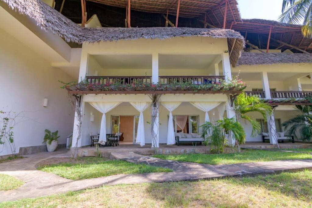 uma casa com uma varanda com flores em Apart No . 112 situated at Lawfords Beach Resort em Malindi