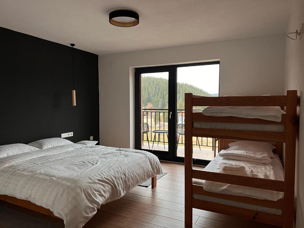 Cabana NORD في Ciban: غرفة نوم بسريرين بطابقين وشرفة