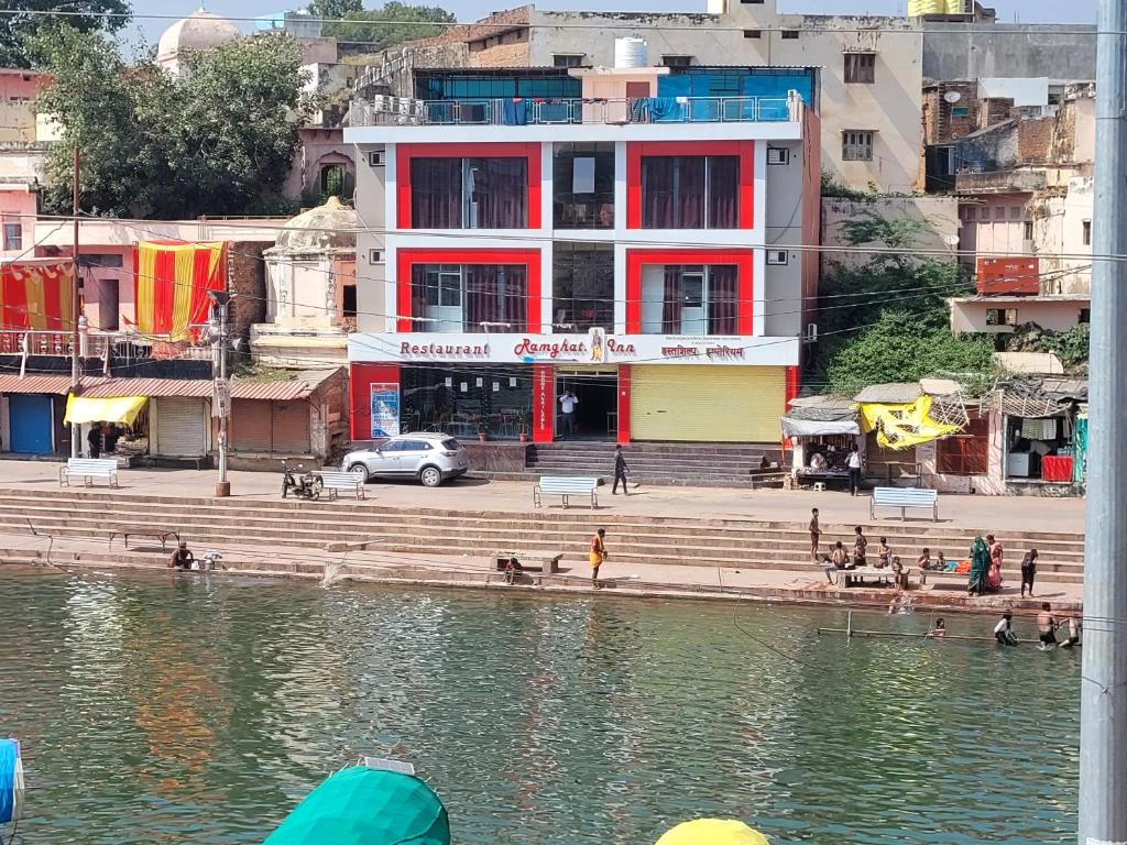 a building on the side of a body of water at Hotel Ram Ghat inn -In Front Of Mandakini River in Sītāpur Mūāfi
