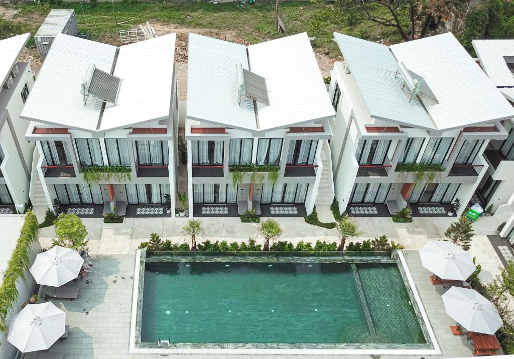 an aerial view of a building with a swimming pool and umbrellas at Emerald Residence Kampot in Kampot