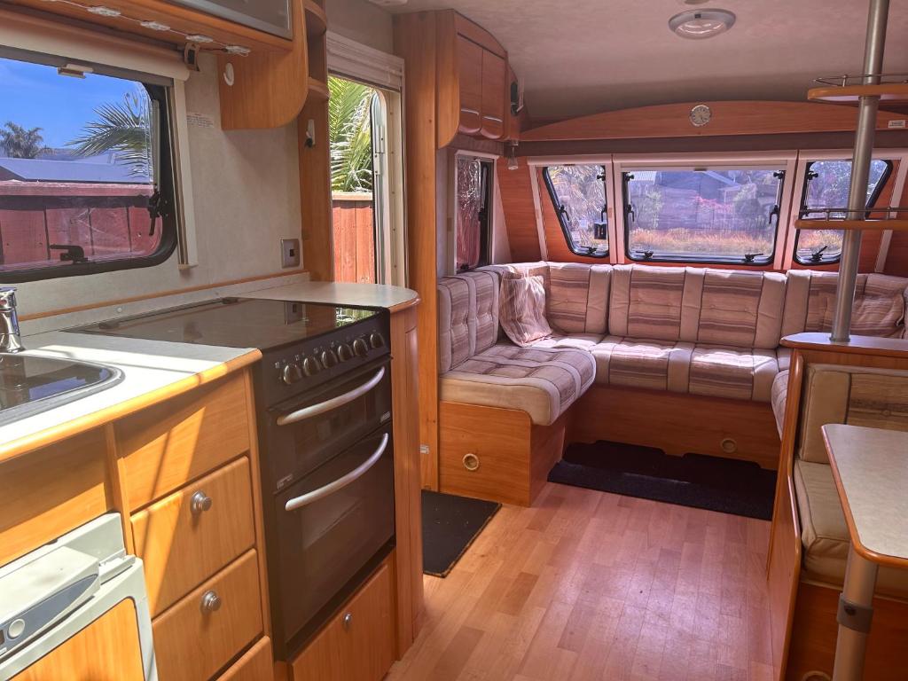 uma cozinha com um fogão e um sofá numa carrinha em Kiwi Caravan Experience em Motueka