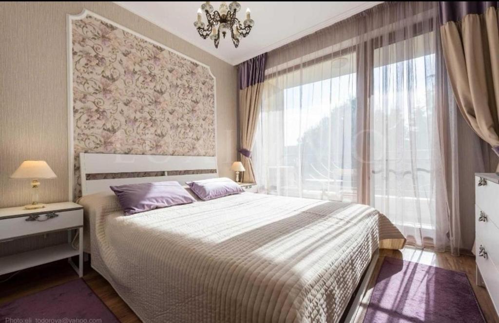a bedroom with a bed and a large window at Luxury apartment Amalfi 300 m from the beach in Varna City