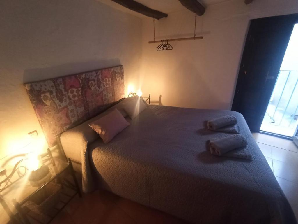 1 dormitorio con 1 cama grande y 2 almohadas en La Afortunaa, en Valdelarco