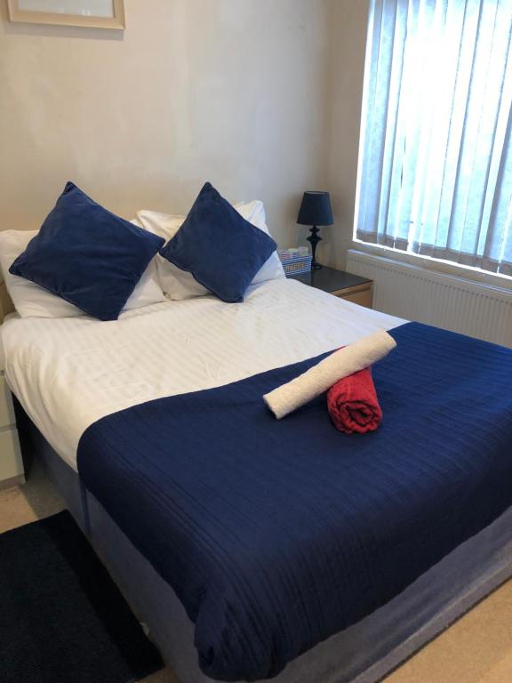 利物浦的住宿－Great Apartman Liverpool，一张带蓝色和白色床单及蓝色枕头的床