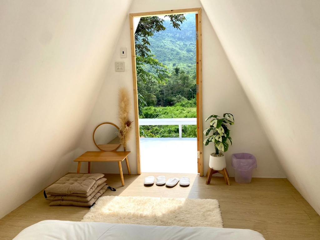 Zimmer mit einem Bett und einem großen Fenster in der Unterkunft Tid Khao Glamping & Bar in Tha Kradan