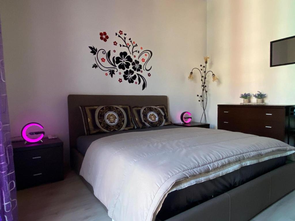 een slaapkamer met een bed met een bloemsticker aan de muur bij Appartamento La Spezia 5 Min Dalla Stazione Centrale in La Spezia