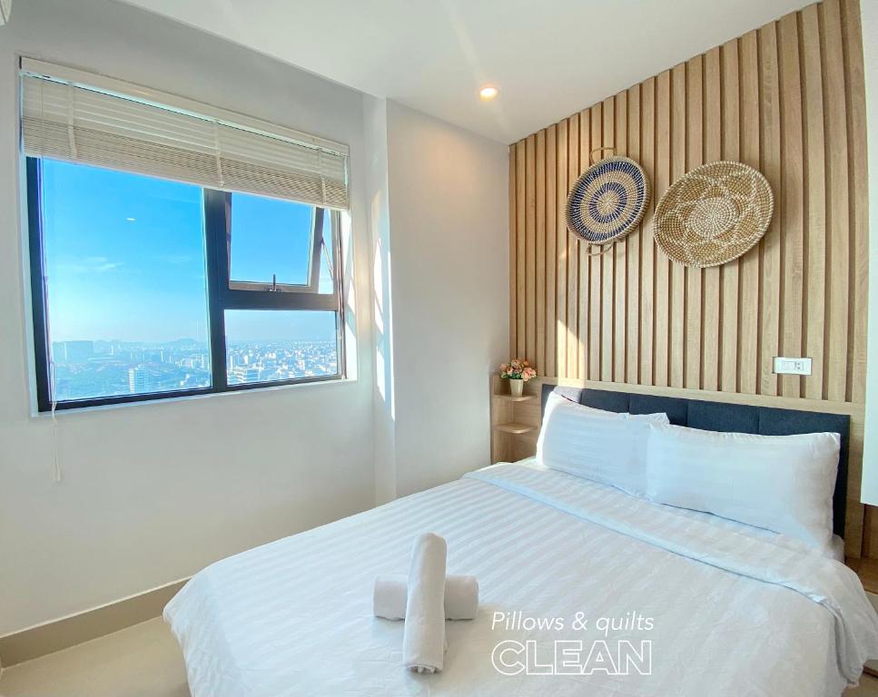 een slaapkamer met een bed met een klok aan de muur bij OPEN VIEW Home at My Khe beach, Danang Mường Thanh Building in Da Nang
