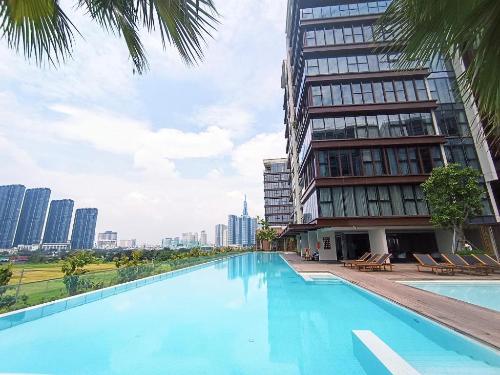 une piscine en face d'un grand bâtiment dans l'établissement Căn hộ cao cấp Metropole, à Hô-Chi-Minh-Ville