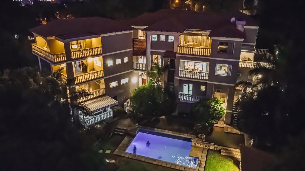 Pretoria的住宿－All Seasons Boutique Hotel，一座建筑,在晚上前方有一个游泳池