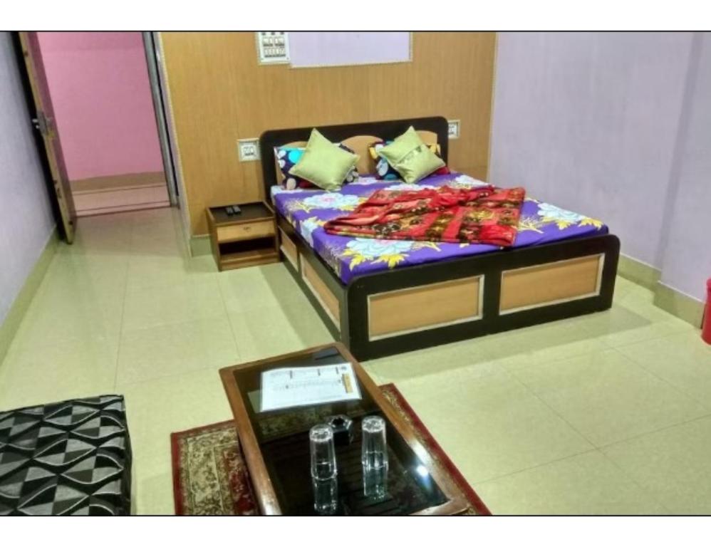 um quarto com uma cama e uma mesa e uma mesa sidx sidx em Hotel Anjali, Deoghar em Deoghar