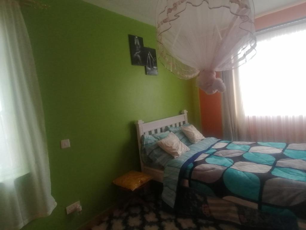 ein Schlafzimmer mit grünen Wänden und einem Bett mit einem Ballon in der Unterkunft FABELLA ACCOMODATION in Machakos