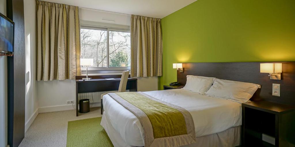 a hotel room with a bed and a window at Domaine de Saint-Paul in Saint-Rémy-lès-Chevreuse