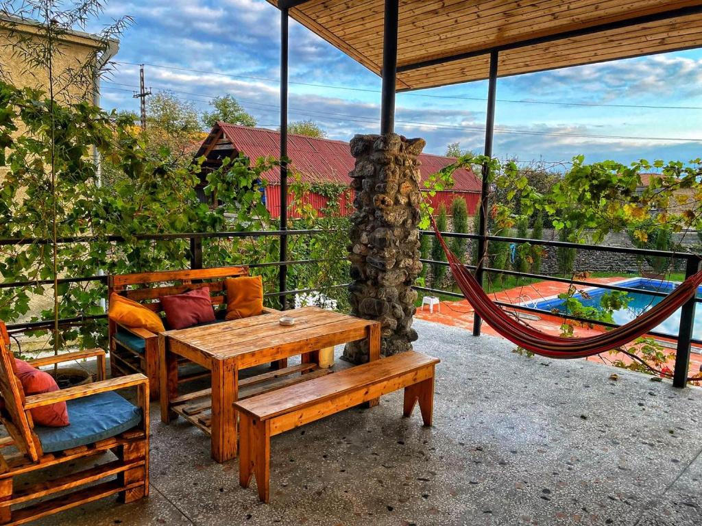 a patio with a hammock and a table and chairs at Varga Kvareli in Kvareli