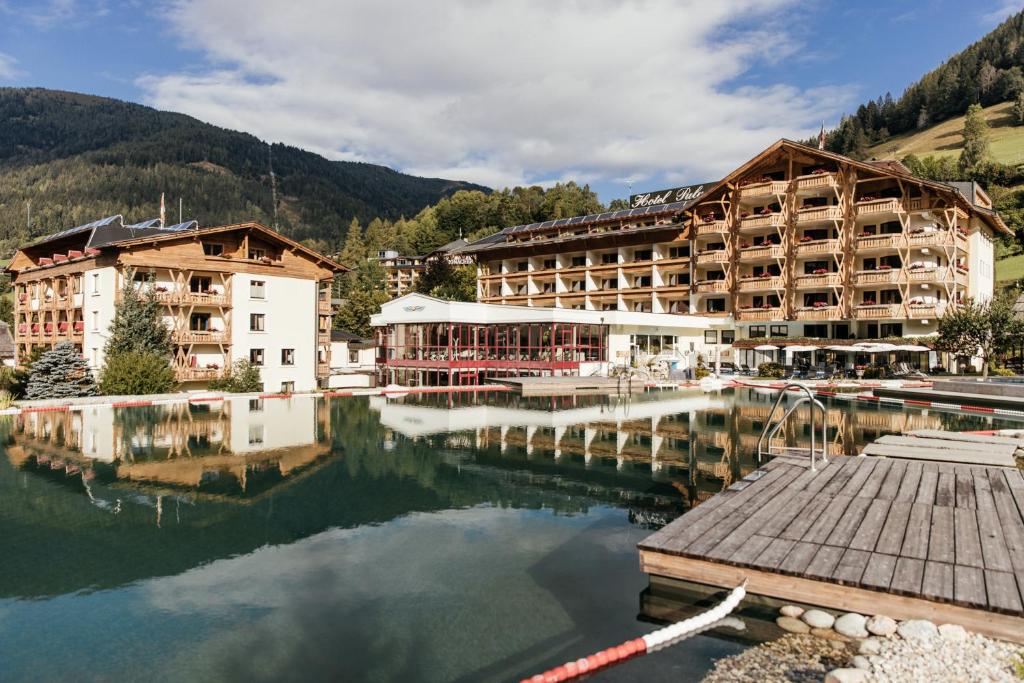 a large hotel next to a body of water at Thermenwelt Hotel Pulverer in Bad Kleinkirchheim
