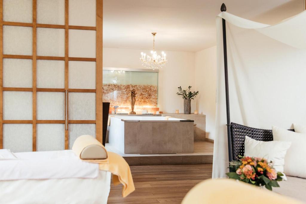 a bedroom with two beds and a bath tub at Thermenwelt Hotel Pulverer in Bad Kleinkirchheim