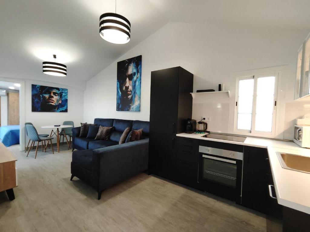 een keuken en een woonkamer met een blauwe bank bij Bungalow "BAHIA AZUL" in Playa del Inglés