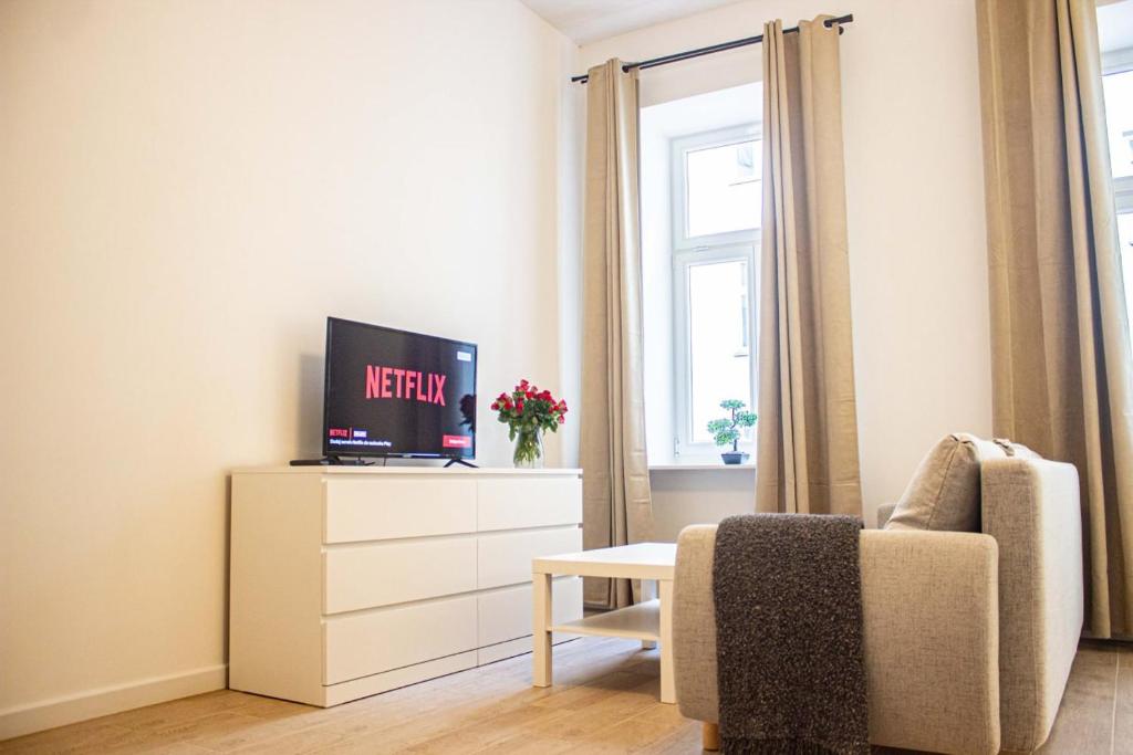 een woonkamer met een tv en een stoel bij Przytulne mieszkanie w Centrum in Warschau