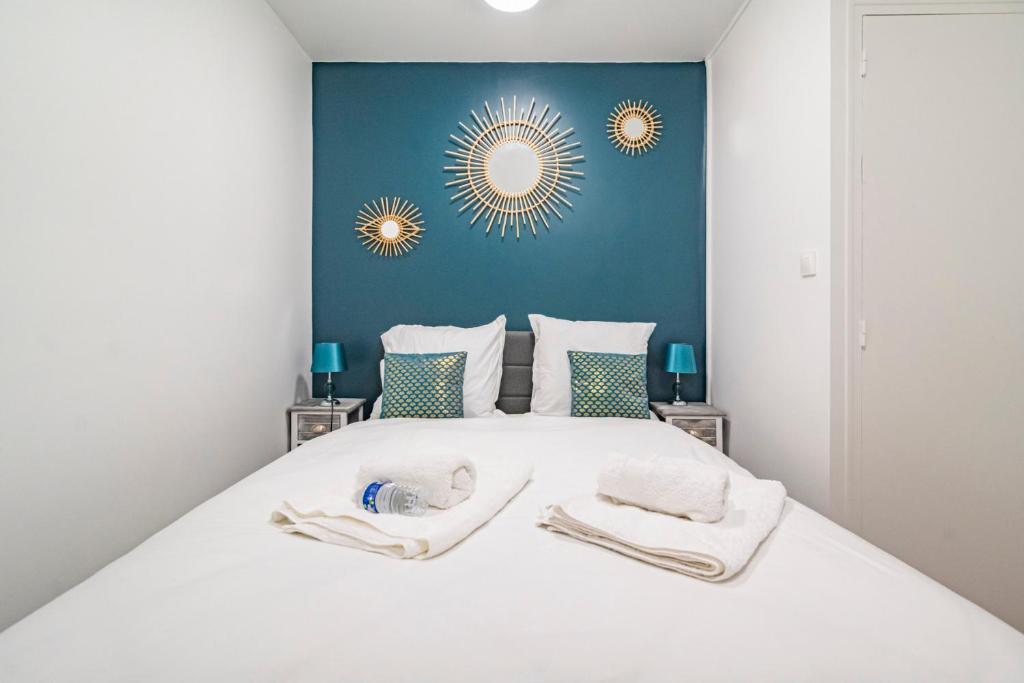 a bedroom with a white bed with two towels on it at Pauline's Home Gambetta - Proche Cathédrale - Calme in Reims