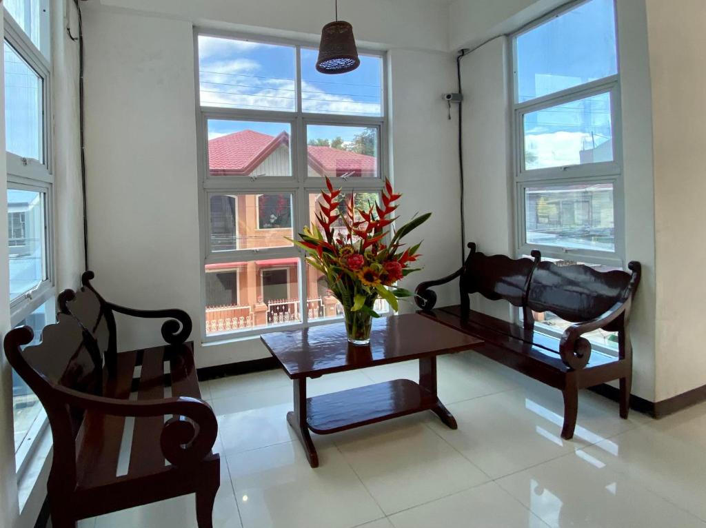a room with a table and two chairs and a window at Three U's Pension House in Palompon