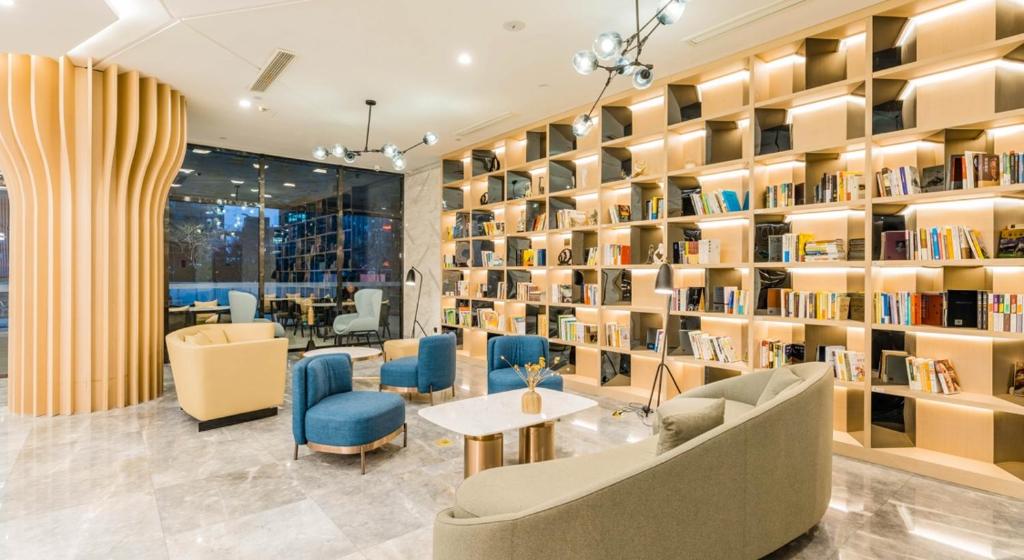 een bibliotheek met veel boekenplanken bij Atour Hotel Hangzhou Qianjiang New Town in Hangzhou