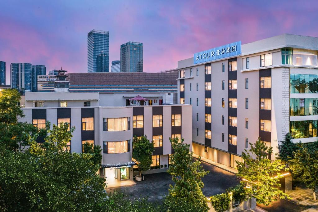 a hotel building with a city skyline in the background at Atour Light Hotel Kunming Dianchi Road South Asia Style First City in Kunming