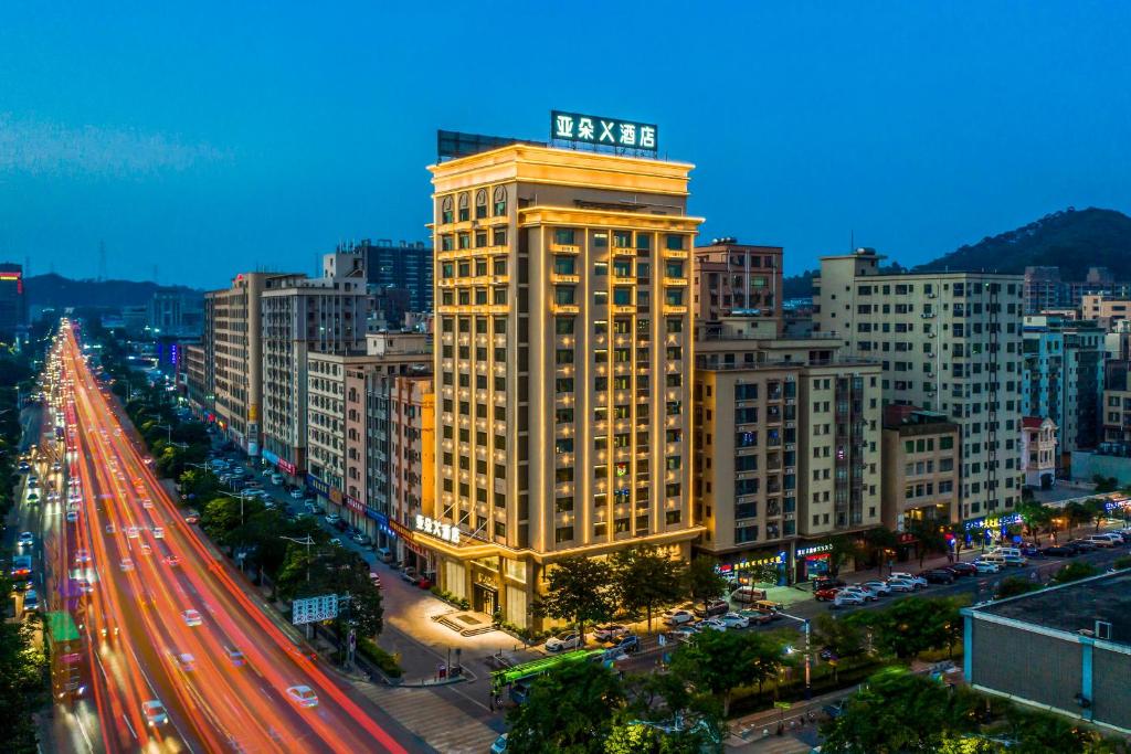 un edificio alto amarillo con un cartel encima en Atour X Hotel Dongguan Chang'an Wanda, en Dongguan