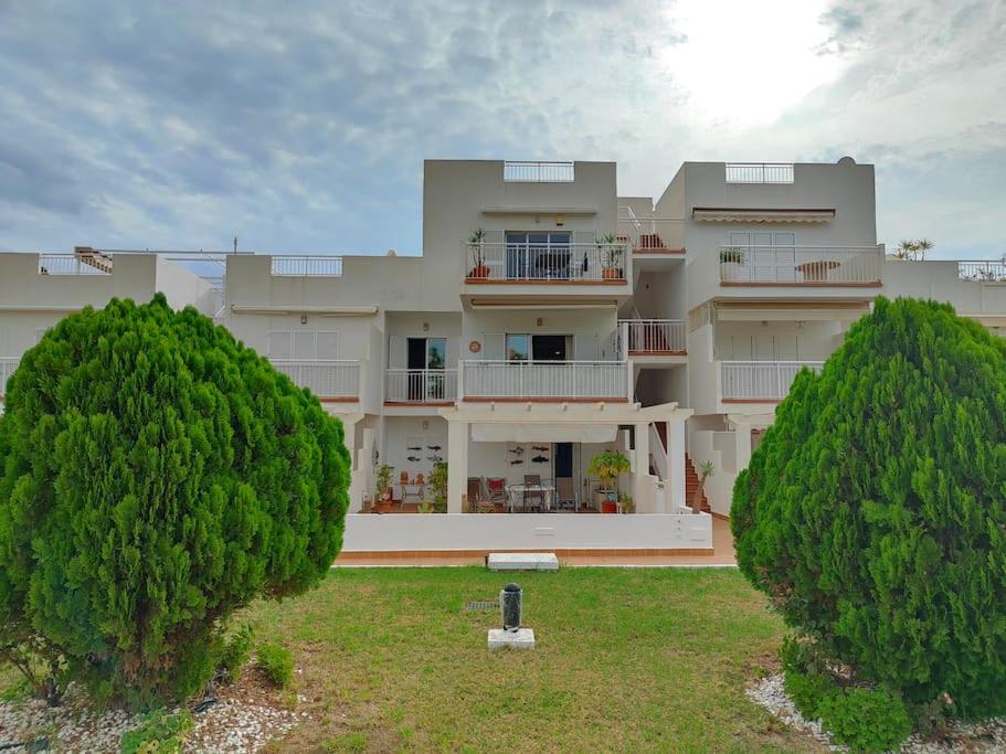 a large building with two trees in front of it at Spacious and luxurious apartment in Mojácar