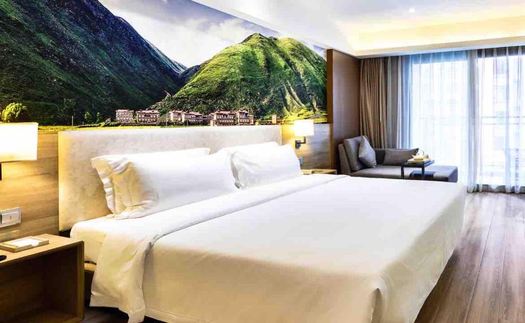um quarto com uma grande cama branca e uma montanha em Atour Hotel Chengdu Consulate South Renmin Road em Chengdu