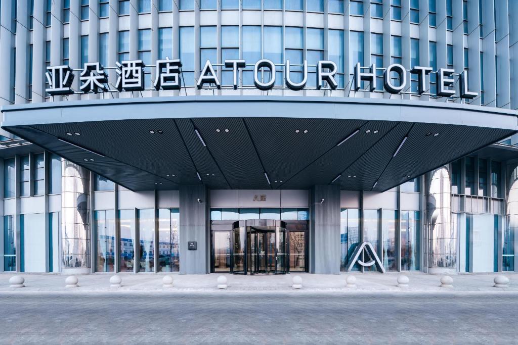 a building with a sign on the front of it at Atour Hotel Tianjin Binhai High Speed Railway Station in Binhai