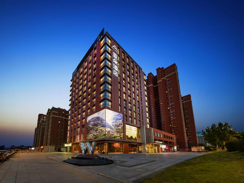 a large building with a large painting on it at Atour Hotel Shenyang South Station Quanyun Road in Shenyang
