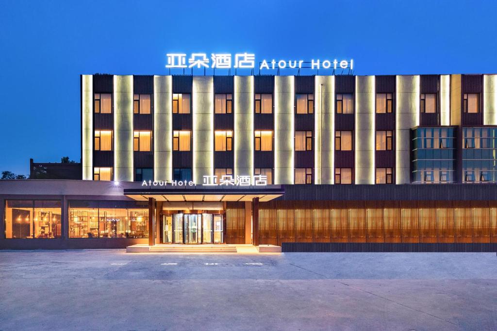 un edificio con un cartel en la parte delantera en Atour Hotel Yantai South Station Yingchun Street, en Yantai